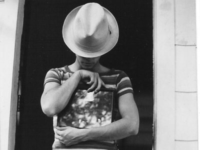 Thomas Evans wearing hat and holding picture with striped shirt.
