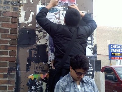 Cecilio helps Edgar get up top so the flyers can not be ripped down